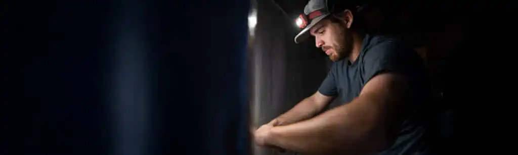 Crawl space encapsulation specialist working on a vapor barrier installation