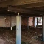 Jacks and girders (floor stabilizers) holding up a house that had moisture damage