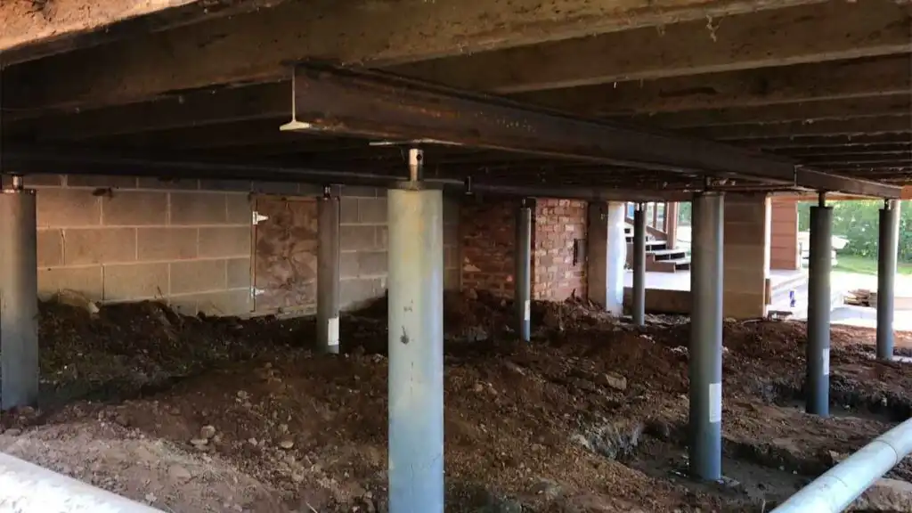 Jacks and girders (floor stabilizers) holding up a house that had moisture damage