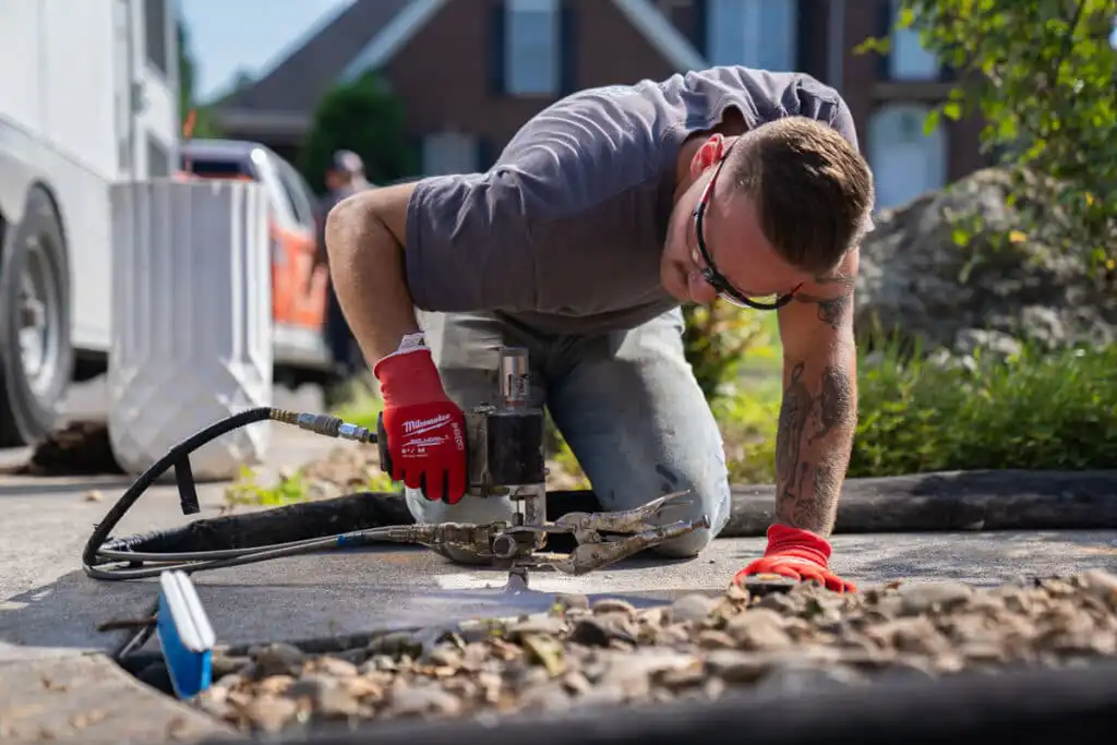 Certified Foundation Specialist injecting polyurethane under sidewalk to level the concrete