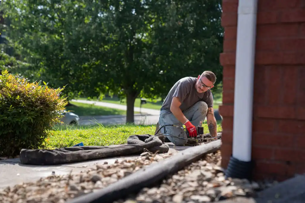 Certified Foundation Specialist injecting polyurethane into sidewalk to level the concrete