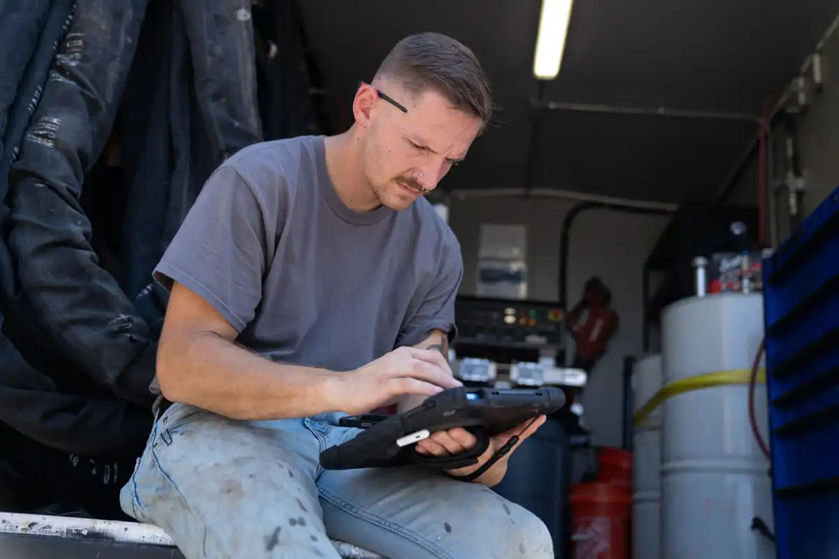 Certified Foundation Specialist review his tablet in a work truck
