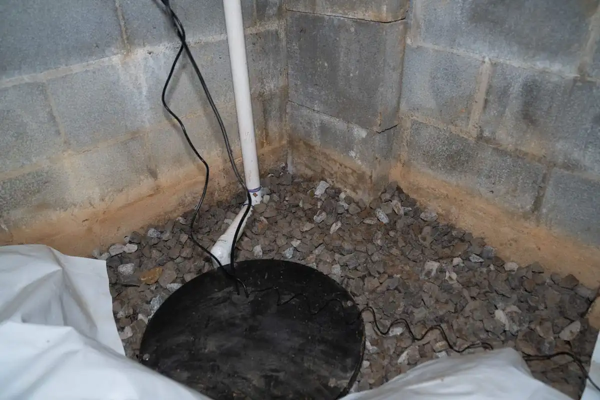 Sump pump lid and discharge line installed in a crawl space