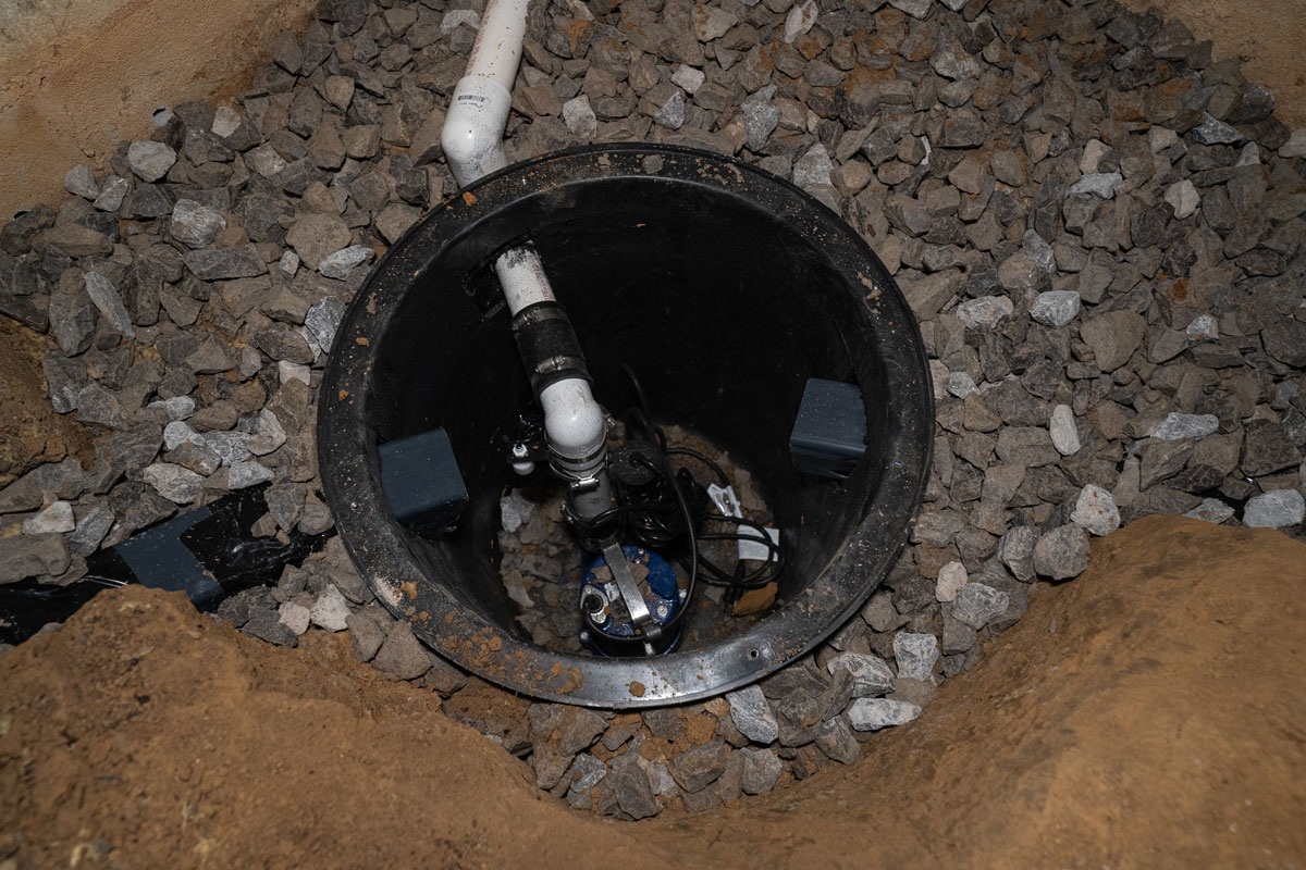 Sump pump and channel installed in a crawl space
