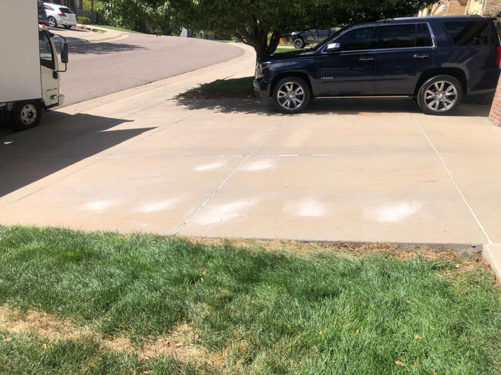 Driveway after concrete leveling with visible holes from drilling
