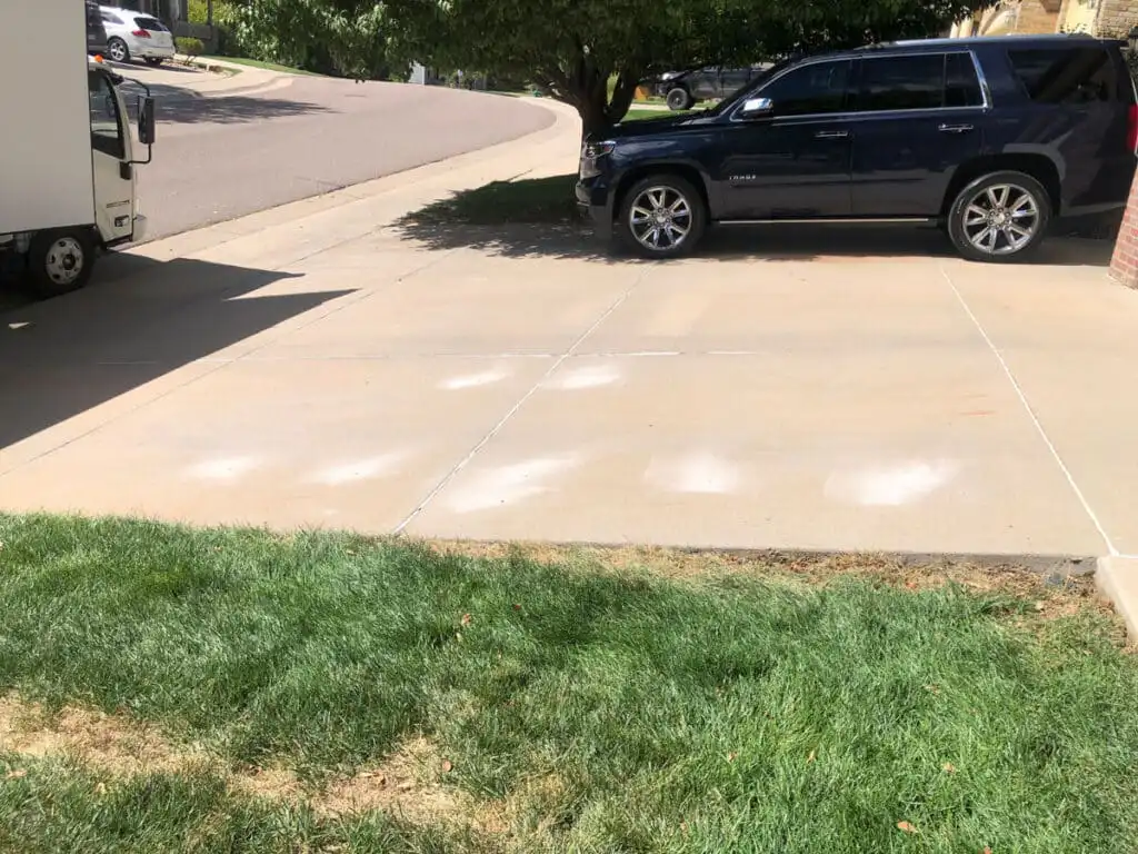 Driveway after concrete leveling with visible holes from drilling