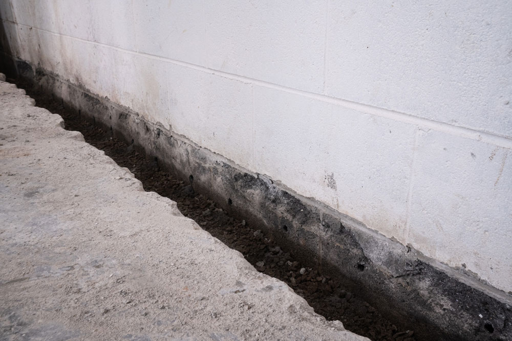 Weep holes and basement perimeter channel drainage system
