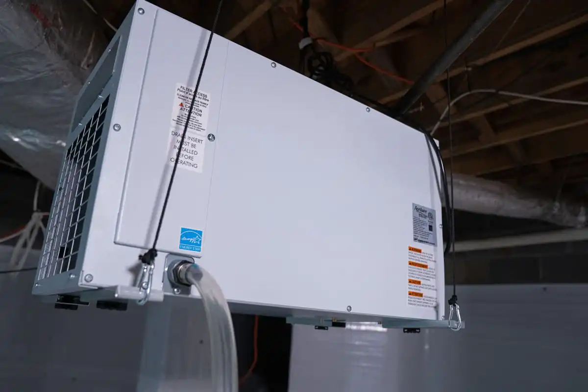 A dehumidifier hung in a crawl space