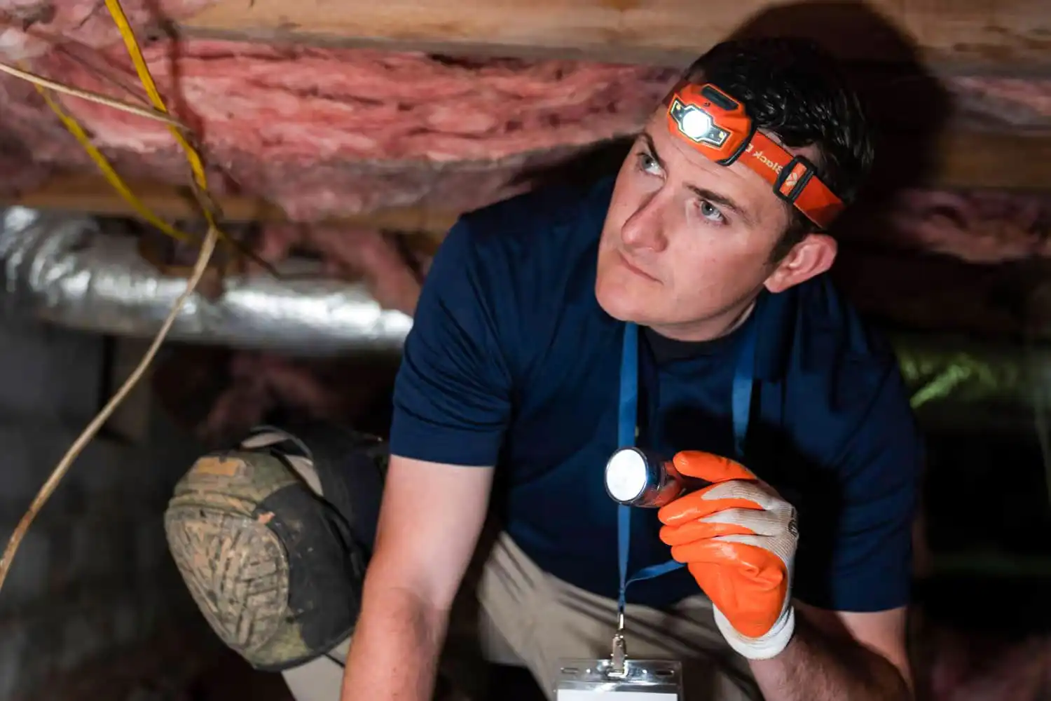 Home repair specialist inspecting a crawl space
