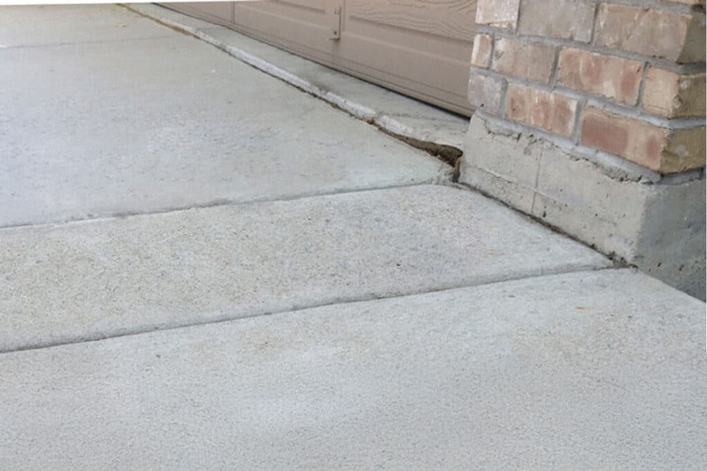 Concrete on driveway in front of garage leveled flat from polyurethane injection