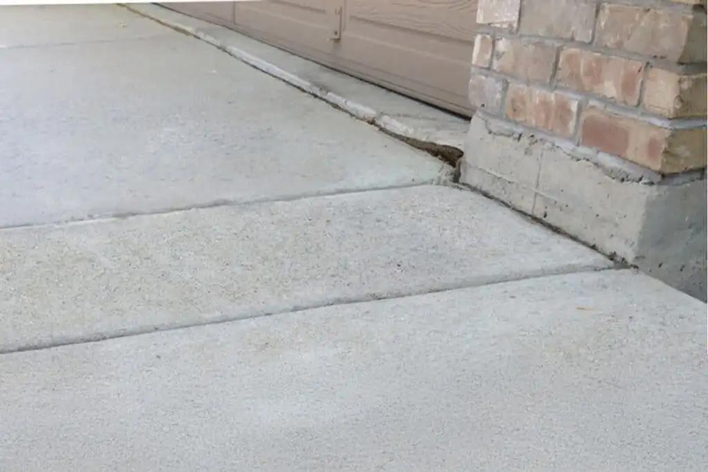 Concrete on driveway in front of garage leveled flat from polyurethane injection