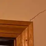 A diagonal drywall crack by a door frame