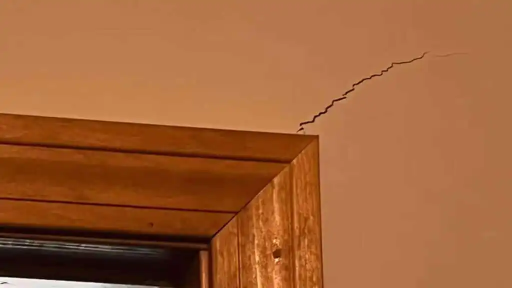 A diagonal drywall crack by a door frame