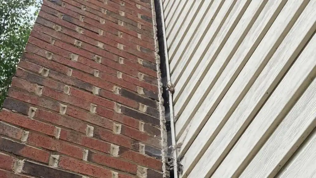 A tilting chimney detaching from a home's exterior due to foundation or waterproofing issues