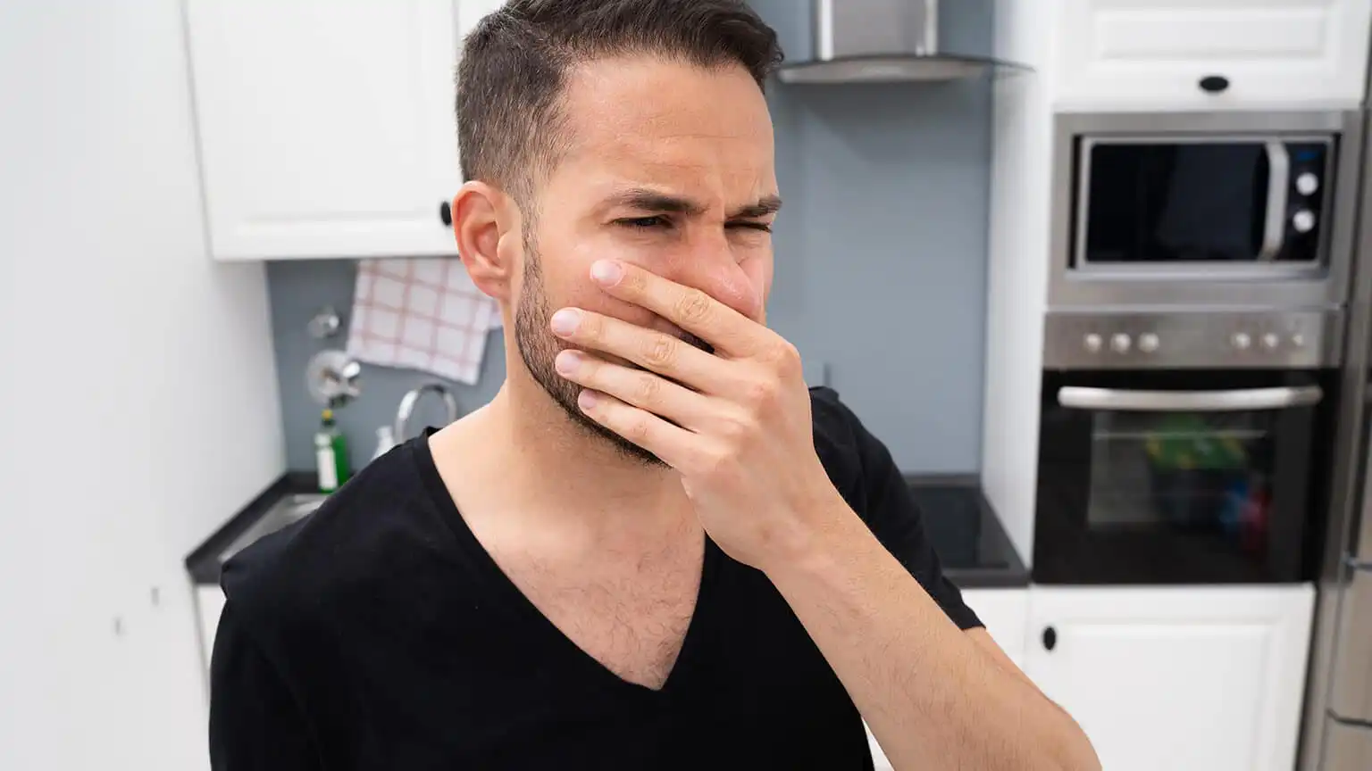 Man plugging his nose after smelling something