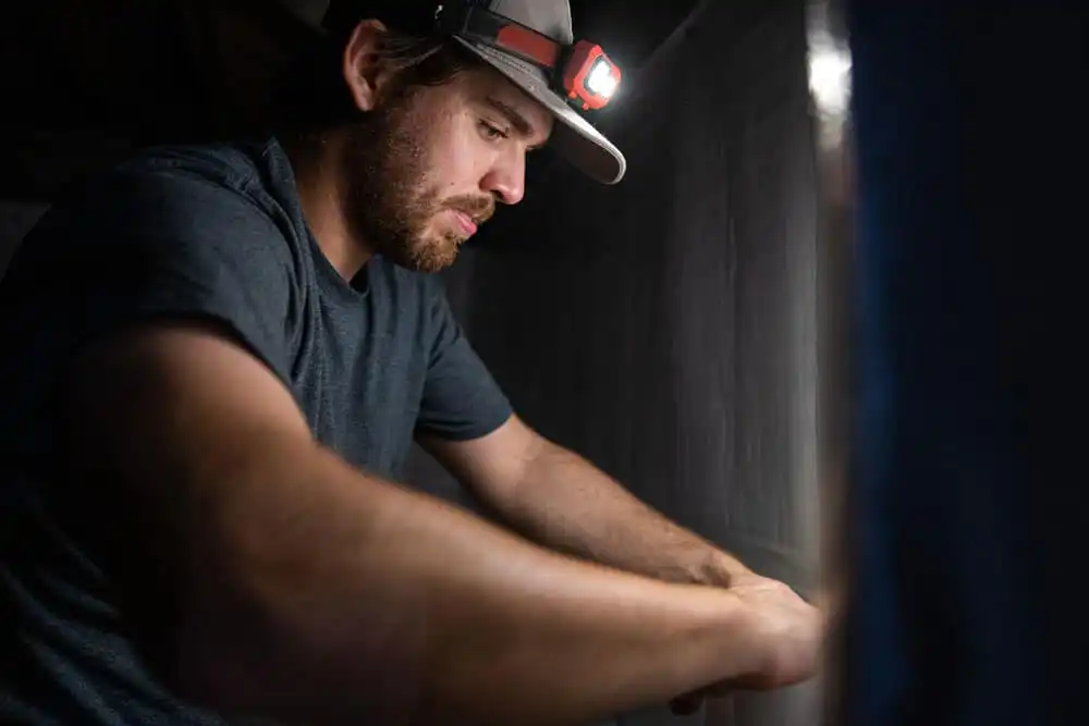 Man performing maintenance on a basement waterproofing system